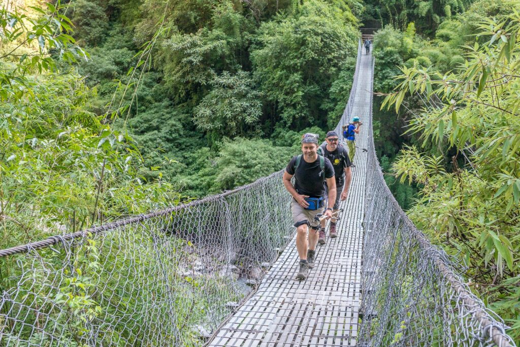 Hängebrücke im Manaslu Trekking Nepal mit Wanderern über dem Fluss " Budhi Gandaki"